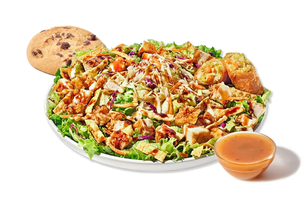 Zaxby's Asian Zensation Zalad™ Boxed Lunch, featuring hand-breaded chicken tenders on a bed of mixed greens, red cabbage, carrots, and wonton strips, topped with Asian slaw and drizzled with honey sesame Teriyaki glaze.