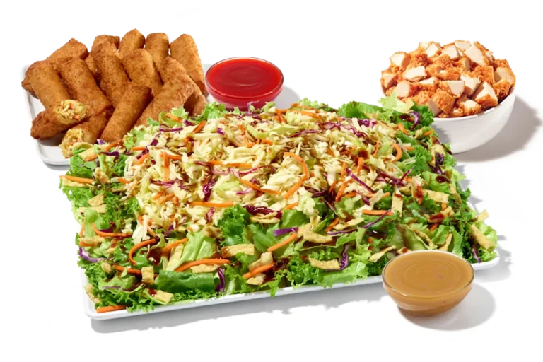 Zaxby’s Asian Zensation Zalad™ Platter featuring mixed greens, fried wontons, crunchy vegetables, and crispy chicken, served with citrus vinaigrette and egg roll.