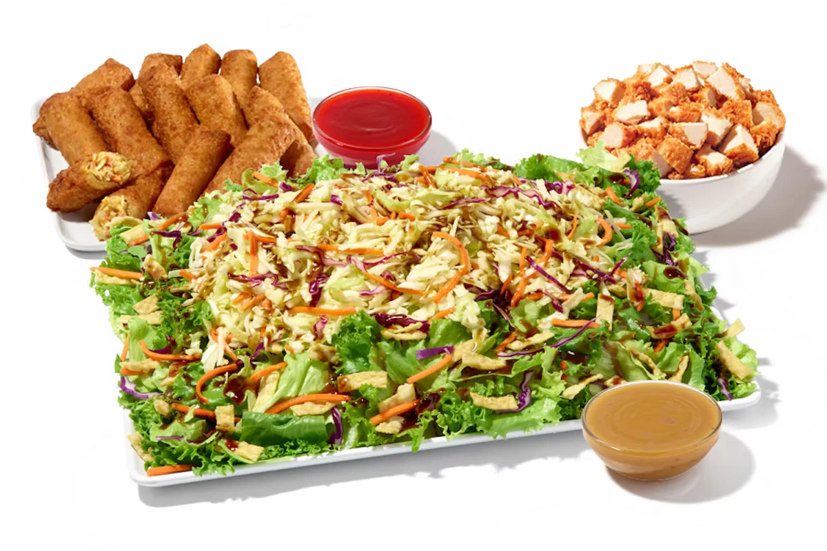 Zaxby’s Asian Zensation Zalad™ Platter featuring mixed greens, fried wontons, crunchy vegetables, and crispy chicken, served with citrus vinaigrette and egg roll.