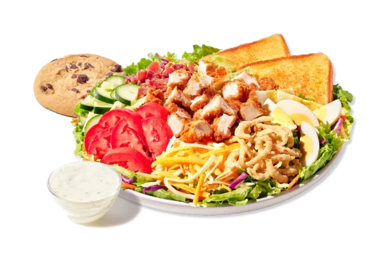 Zaxby's Cobb Zalad® Boxed Lunch, featuring a fresh salad with grilled or fried chicken, bacon, hard-boiled egg, Cheddar Jack cheese, cucumbers, tomatoes, and fried onions, accompanied by Texas Toast and a chocolate chip cookie.