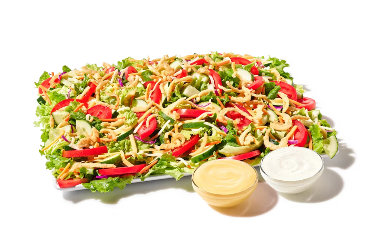 A fresh Zaxby’s Garden Zalad® Platter with mixed greens, cucumbers, grape tomatoes, shredded cheese, and crunchy fried onions.